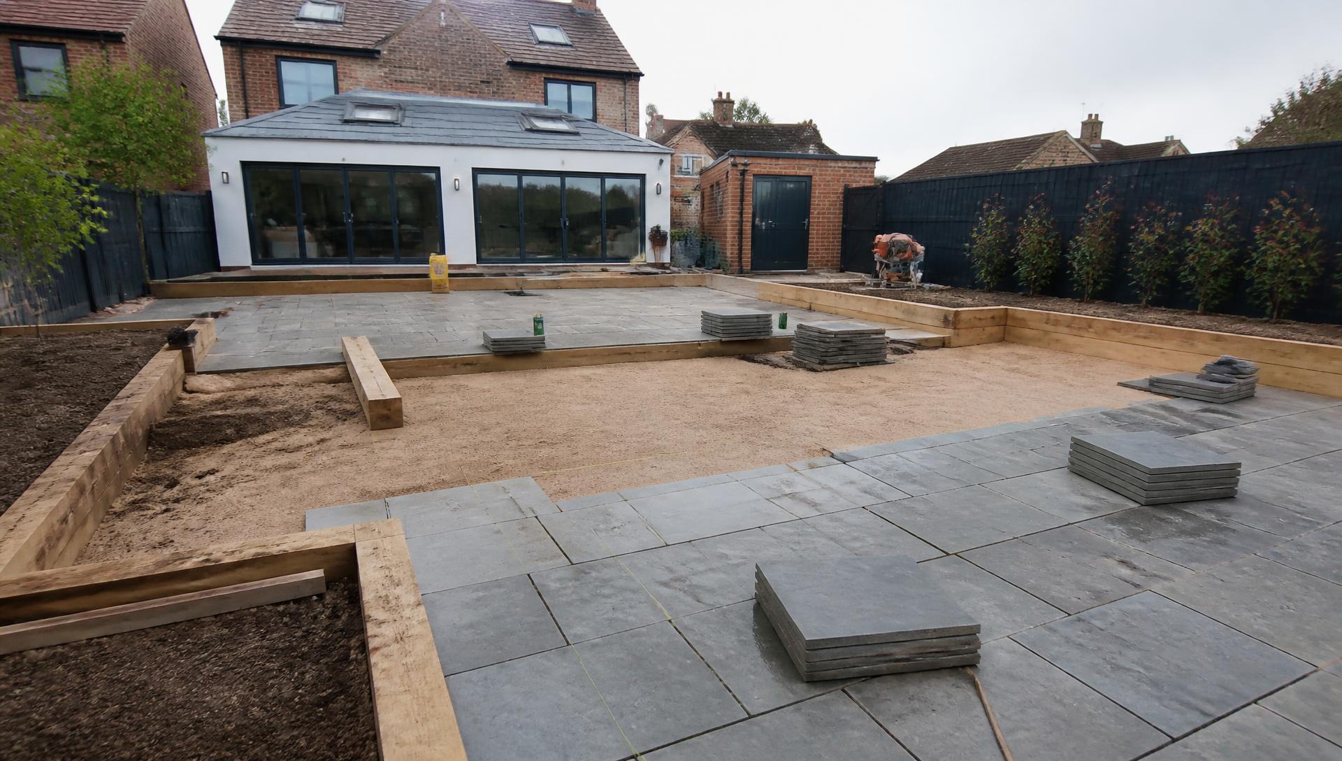 Landscaping project in progress with paving slabs being laid in a garden